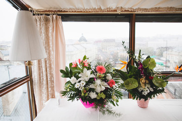Two bouquets of flowers at the window