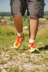 Man walking on sidewalk, sport shoes