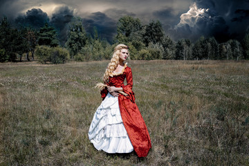 Blonde woman with long curly hair with flower accessory in antique red dress