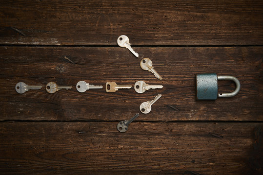 Arrow pointing the keys to the lock on wooden boards