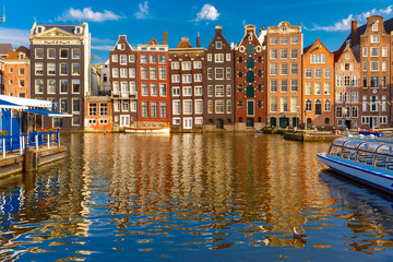 Naklejka premium Beautiful typical Dutch dancing houses at the Amsterdam canal Damrak in sunny day, Holland, Netherlands.