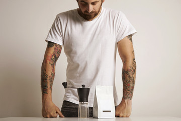 Man with a coffee grinder and bag of coffee beans