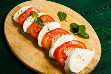 Sandwich from sliced tomatoes, mozzarella, basil and baguette 
