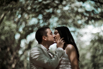 happy man kissing his bride in garden
