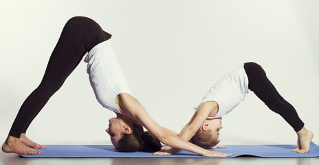 mother and son doing yoga (sports exercises), have fun and spend a good time together . isolated on...