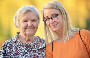 Grandmother and granddaughter. Young woman carefully takes care