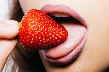 female lips eating red strawberry