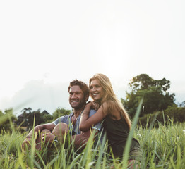 Loving couple sitting on grass field © Jacob Lund