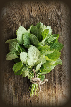 Fresh mint leaves herb on rustic wooden table.