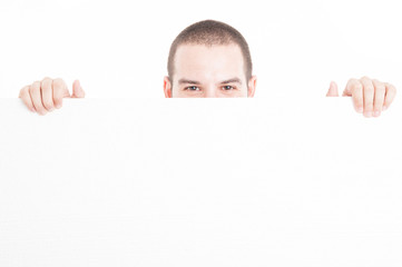 Supermarket seller hiding from big advertising board