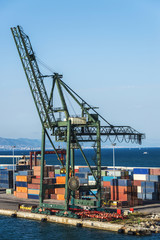 Huge port crane surrounded by containers