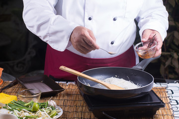 Chef putting tamarine sauce for cooking Pad Thai