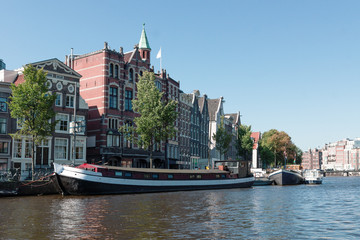 Fototapeta premium Houses and barges on the river Amstel in Amsterdam