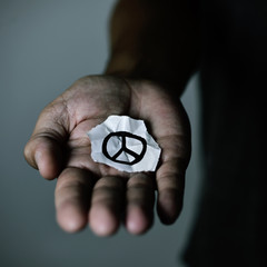 man with a peace symbol in a piece of paper