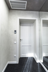Classical closed wooden door in white office wall
