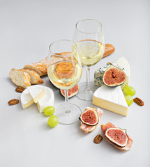 wine and snacks on grey table