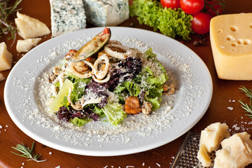 Warm salad with seafood, boiled eggs, lemon, red caviar and raw