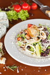 Warm salad with seafood, boiled eggs, lemon, red caviar and raw