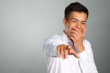 Portrait of a young man pointing his finger at you