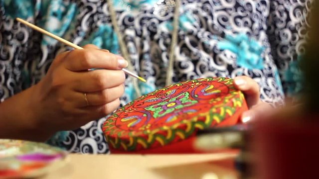 paints with a brush on wood