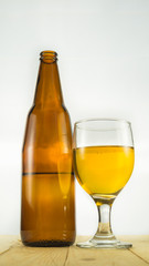 Beer bottle and goblet on white background