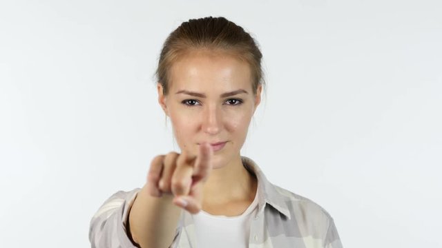 Young girl pointing finger to the camera in front of white background