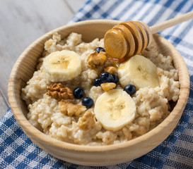 Oatmeal porridge with bananas, blueberries and honey