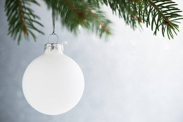White christmas ball on the xmas tree on glitter bokeh background. Merry christmas card. Winter...