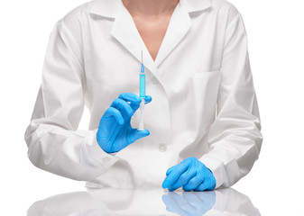 Doctor in white gown and gloves holding syringe with drug