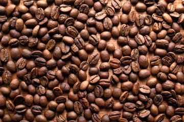 Top view of roasted coffee beans on wood background