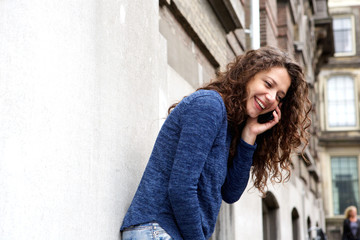 Young woman talking on mobile phone and smiling outdoors