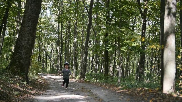 Little girl running forward in the forest