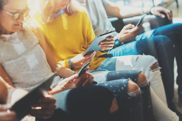 Fototapeta premium Group Young Hipsters Friends Sitting Sofa Using Modern Gadgets.Business Startup Friendship Teamwork Concept.Creative People Working Together Marketing Project.Coworking Process Office Studio.Flares.