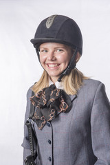Portrait image of a smiling, happy young blonde horse rider. 