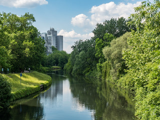 Fototapeta na wymiar Canal in Berlin with trees on sides, building in background
