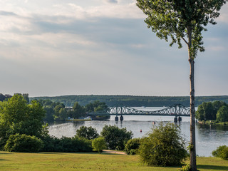 sunset over a park with lake and bridge in background