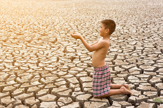 Child sit on cracked earth in the arid area