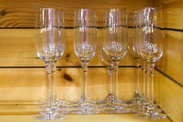 Empty glasses for champagne on the wooden shelf.