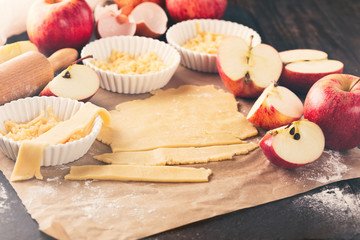 Baking Apple Pie Ingredients - fresh apples, flour, eggs and sugar on rustic dark background, selective focus. Toned image.