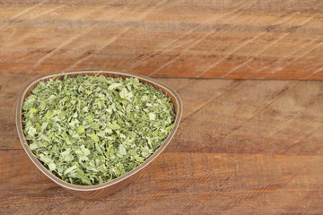 Moringa leaves on wooden background