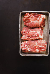 Raw pork chop. Three thick steak in oven sheet.