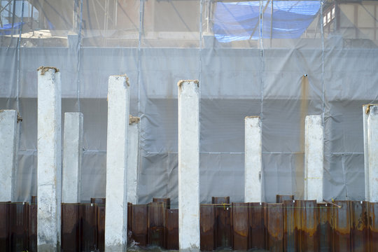 architectural background with scaffolding and blue protective netting surrounding a building under renovation