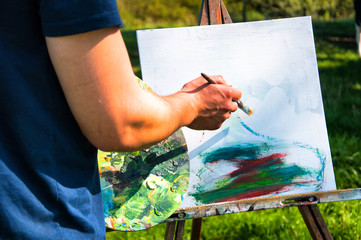 Man painting a picture in the open air