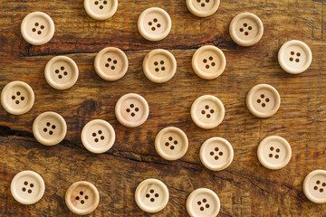 Collection of wooden buttons on wooden background