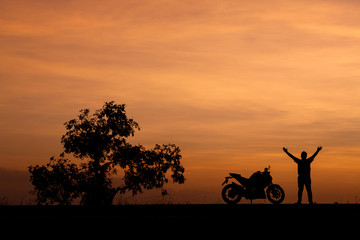 Silhouette man and his motorcycle To live a lifestyle. with beautiful the sky at sunset..Background,