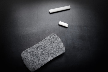 piece of chalk and eraser on blackboard