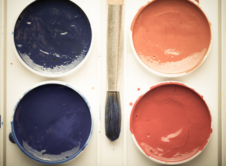 Colorful watercolor paints in palette with brush. Toned