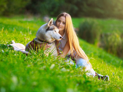 Attractive young woman hugs funny siberian husky dog