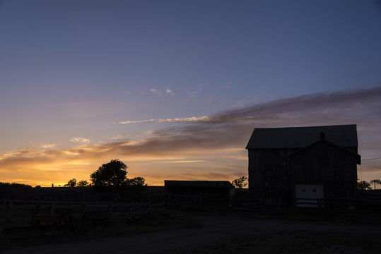 Barn silhouetted by sunset