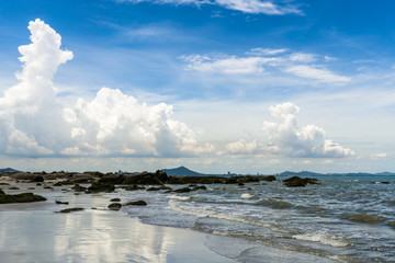 Seascape in sunny day with blue sky and white clouds